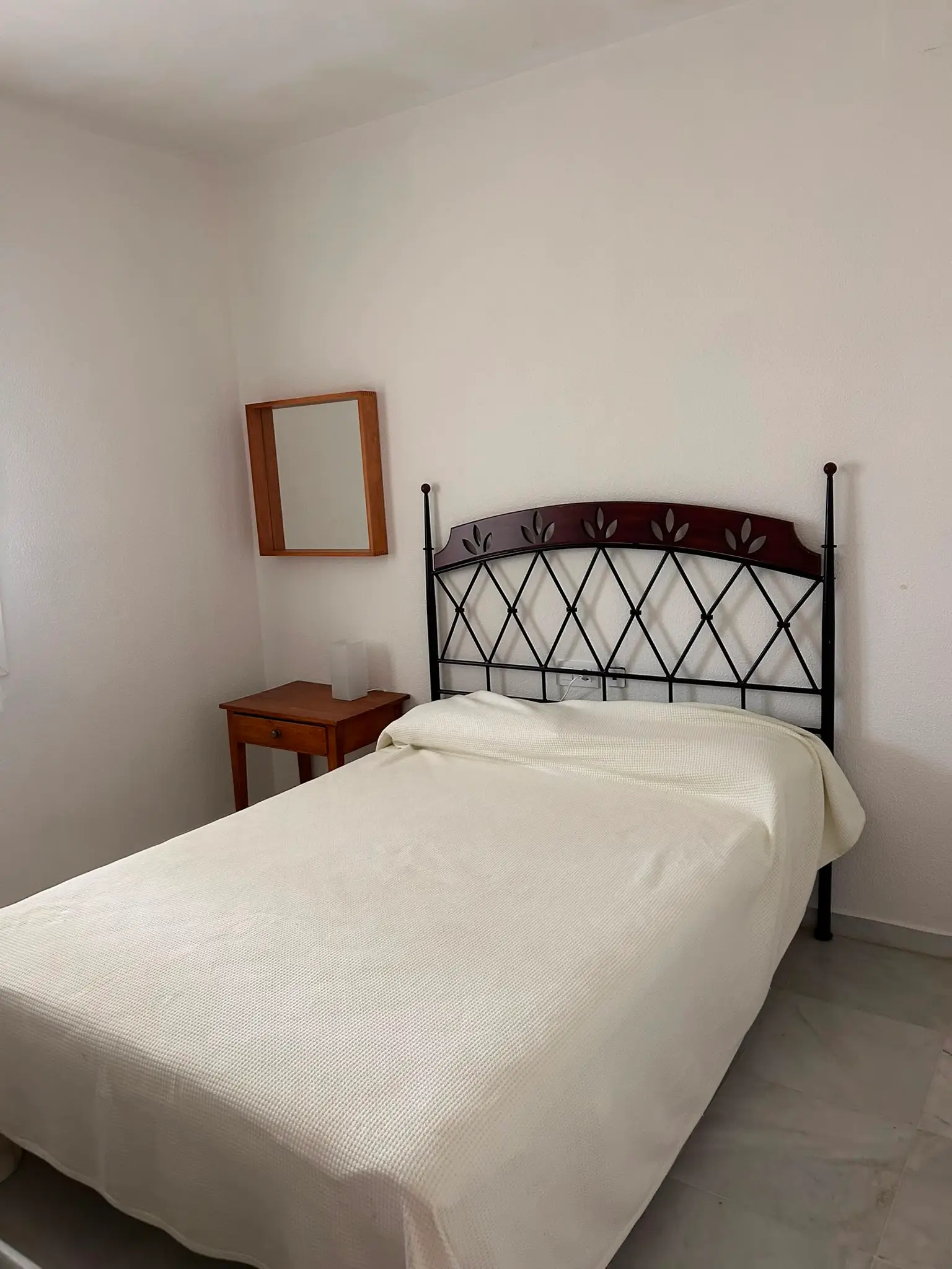 Dormitorio principal con cama doble y cabecero de forja